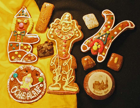 Foto einer Sammlung unterschiedlicher Aachener Printen in klassischen Tafeln und in Sonderformen, u.a. verschiedene Clowns, Schokoladen-Nuss- und Mandelmppchen, Karnevalsorden und bedruckter Marzipanauflage mit 'Aachener Dom'-Motiv